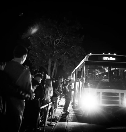 top-value A group of people sitting on a bus, each holding drinks and engaged in conversation.